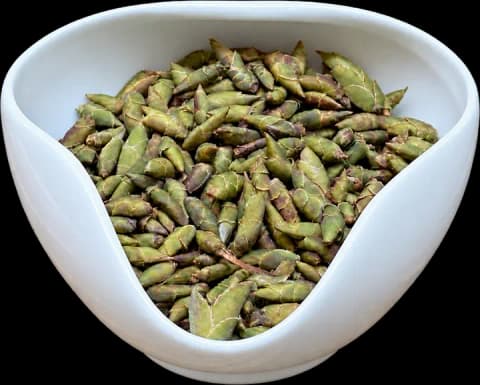 Dragon Claw white tea buds in a white porcelain display bowl